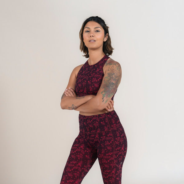 Woman wearing a maroon patterned athletic outfit on a white background