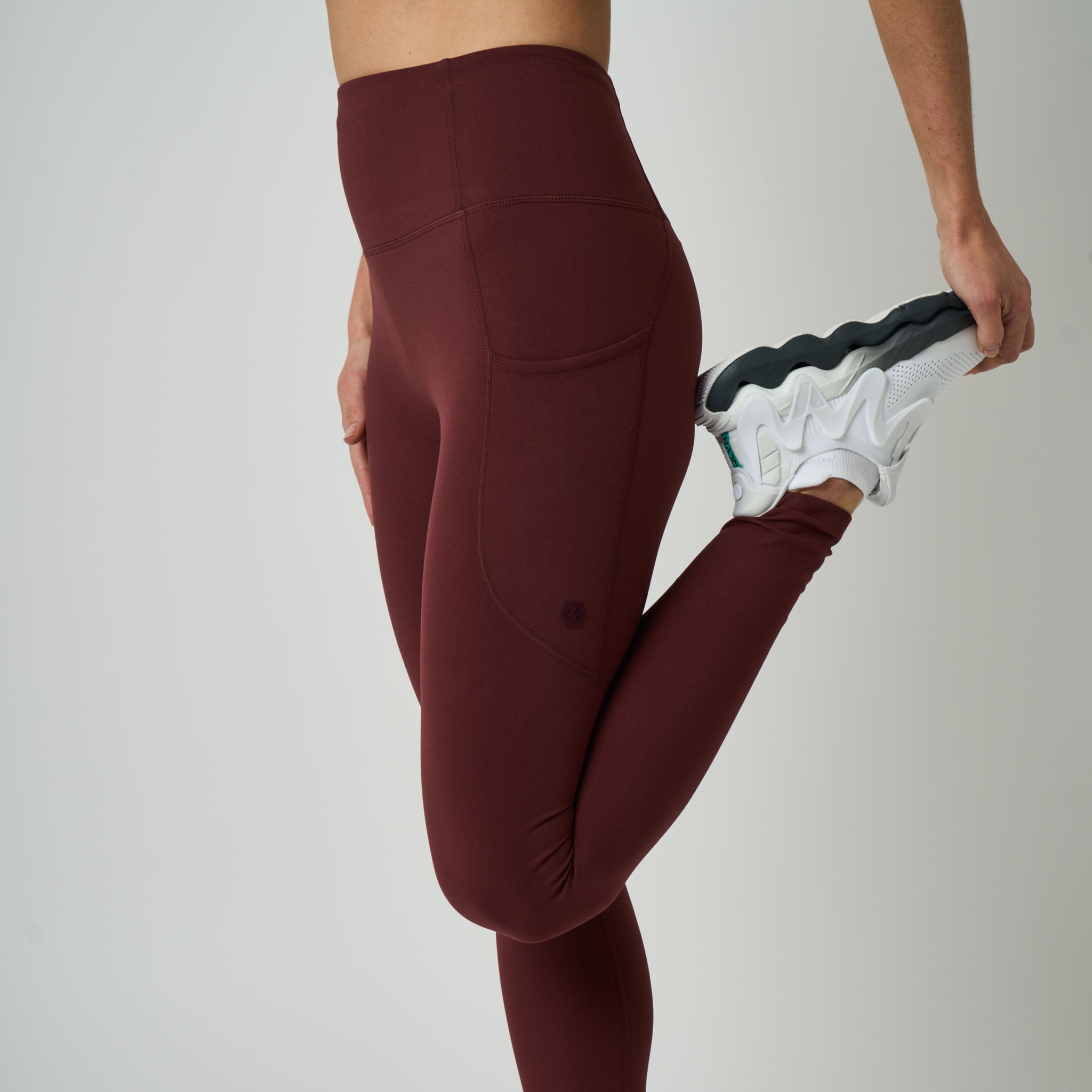 Maroon leggings worn by a person on a plain background