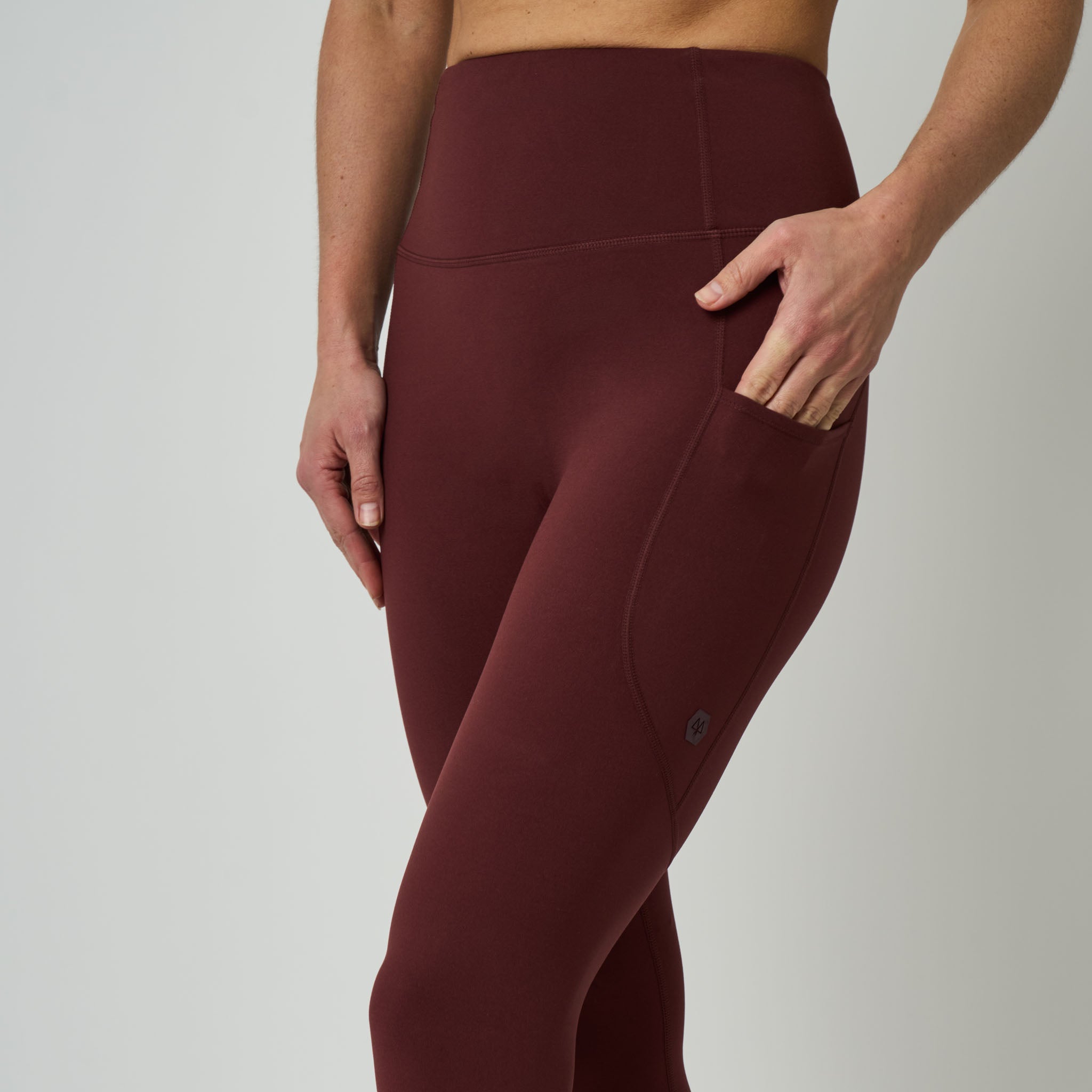 Maroon leggings worn by a person on a plain background