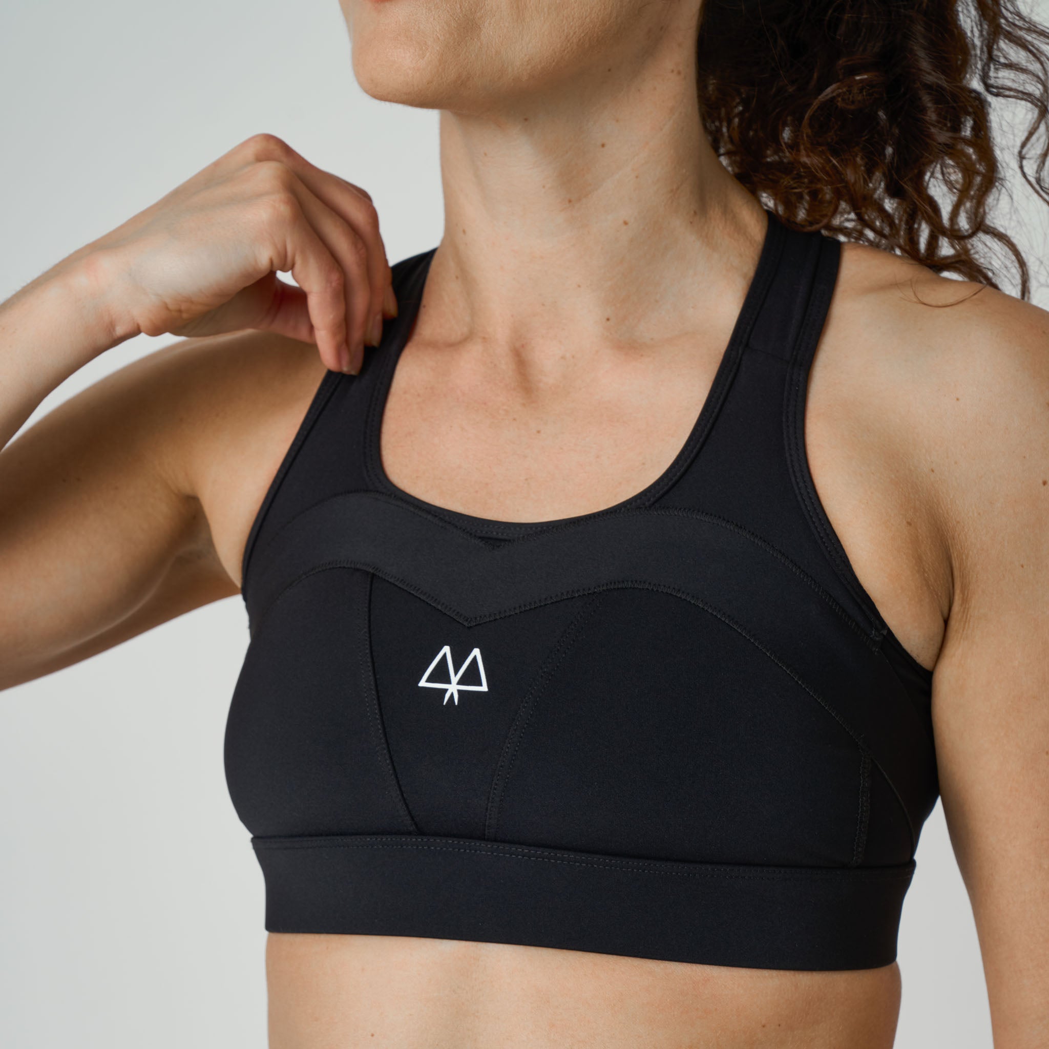Black sports bra with a MAAREE logo on a neutral background