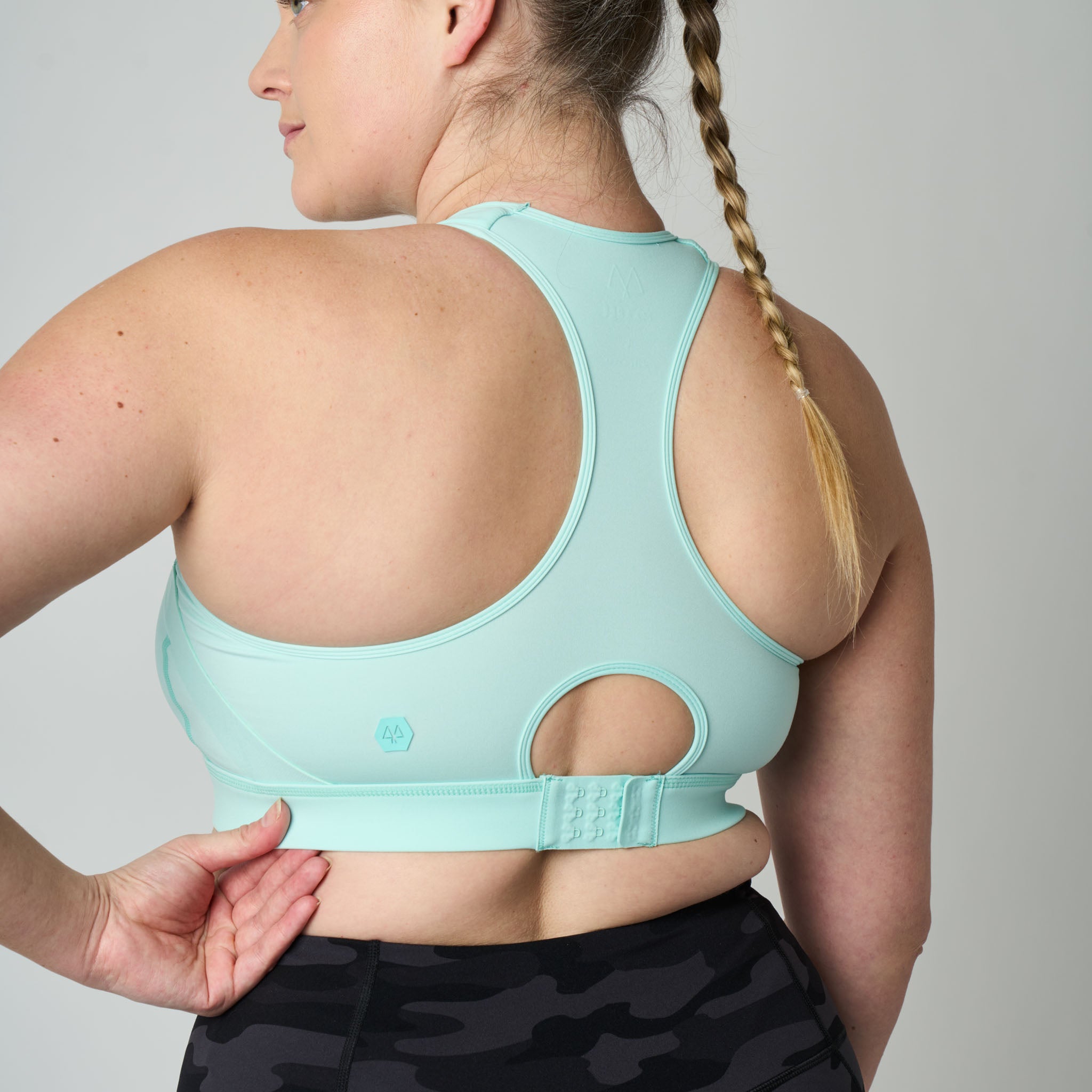 Person wearing a light blue sports bra with a plain background