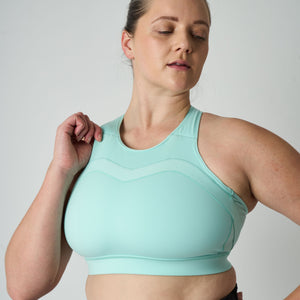 Woman wearing a light blue sports bra against a plain background