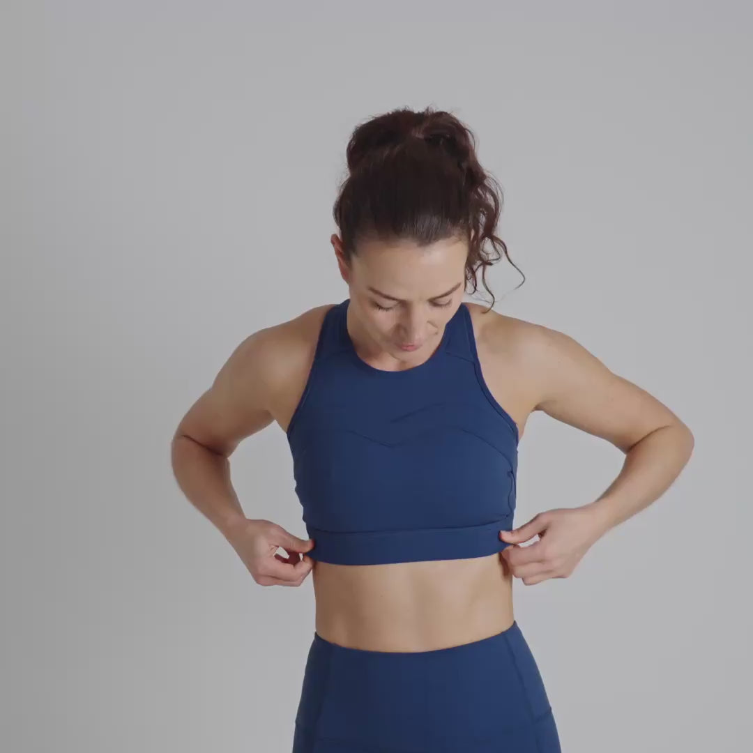 Blue sports bra worn by a person on a plain background